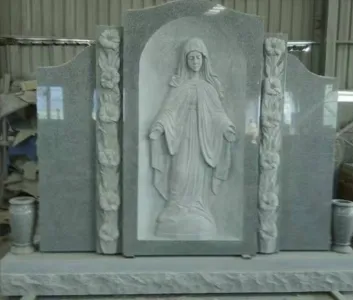 Carved Madonna relief monument framed by floral columns