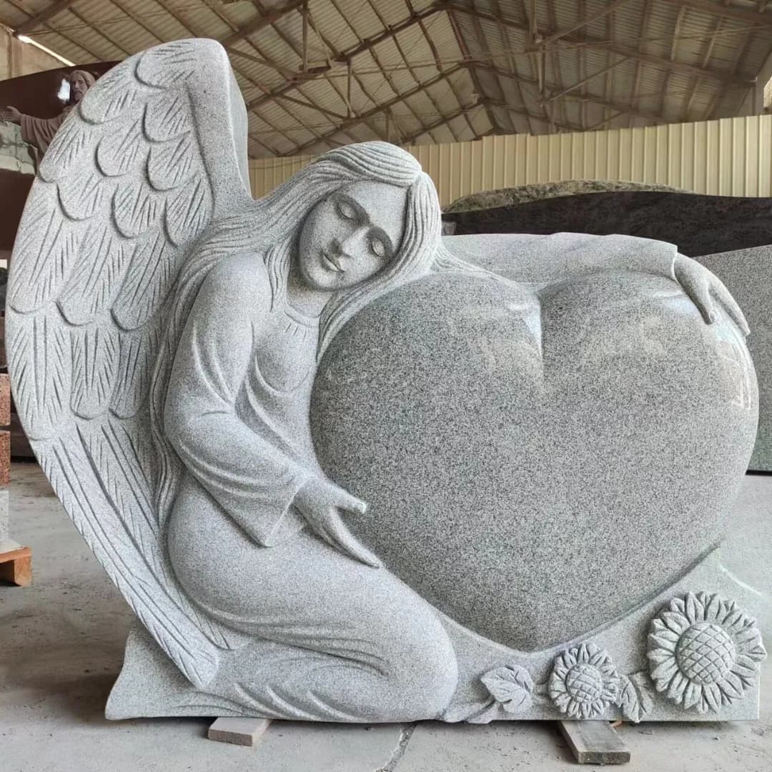Carved granite angel resting against a polished heart