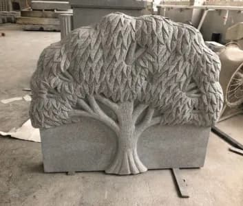 Tree-of-life sculpted in relief across a granite tablet
