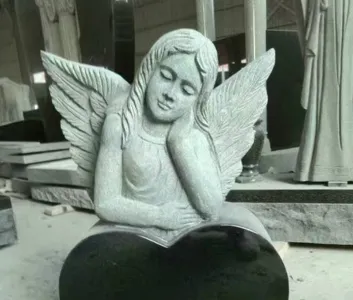 Sculpted angel resting on a polished heart-shaped base